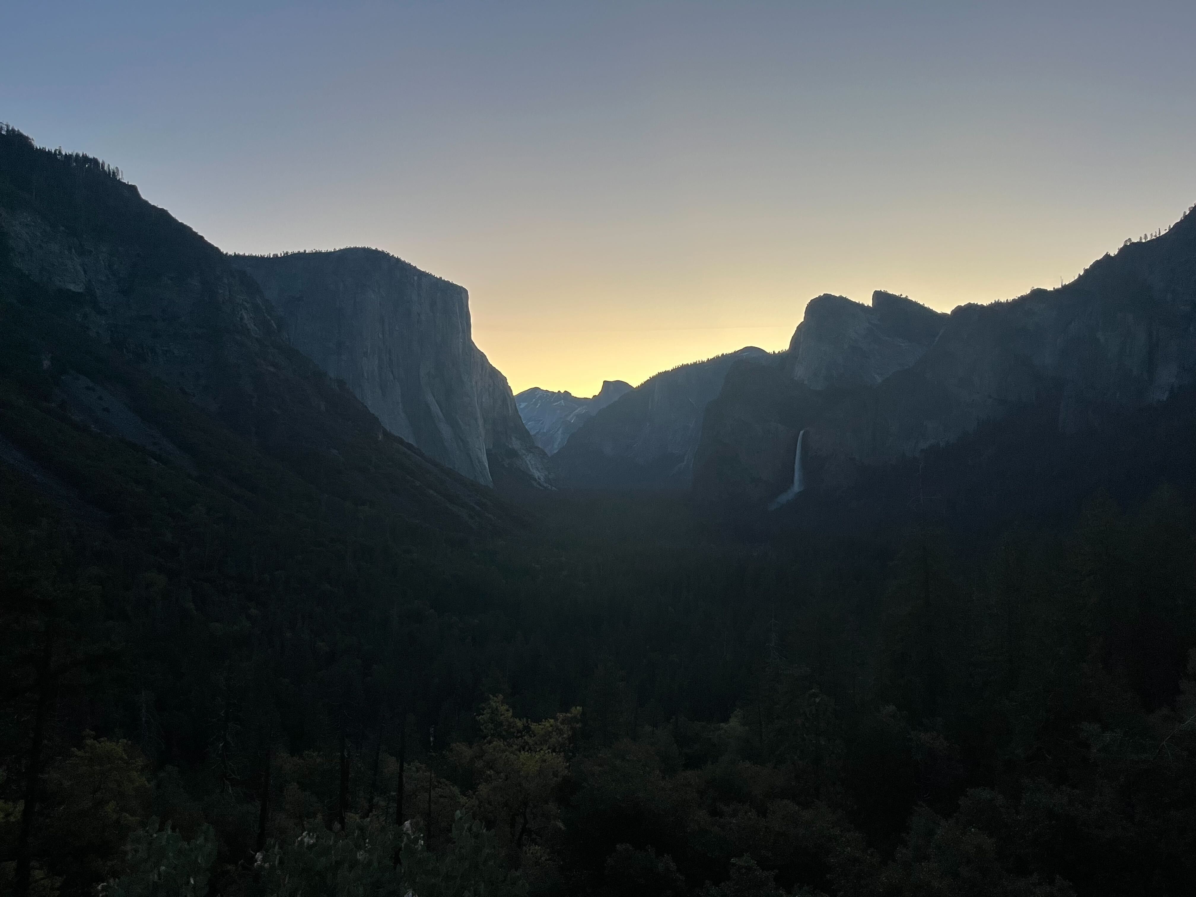 Yosemite Valley at sunrise, with El Capitan and Bridalveil Fall visible in the distance.